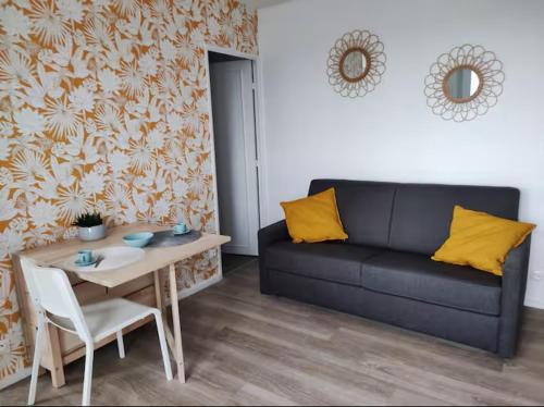 a living room with a couch and a table at Vue Mer sur Juno Beach - Studio in Courseulles-sur-Mer