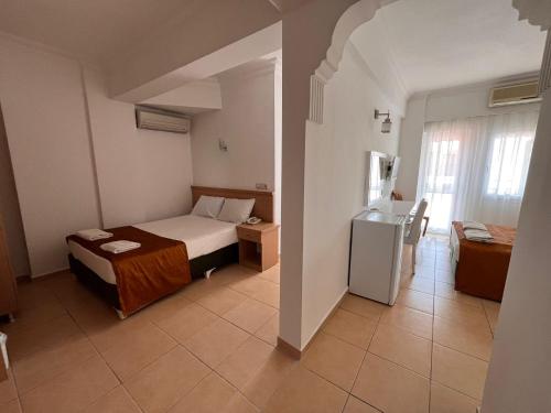 a room with a bed and a refrigerator in it at Taner Otel in Oludeniz