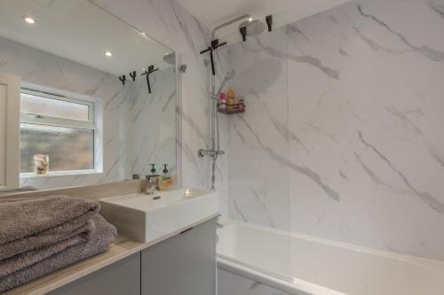 a white bathroom with a sink and a tub at High End Central Location 2 Bedroom in Stoke on Trent
