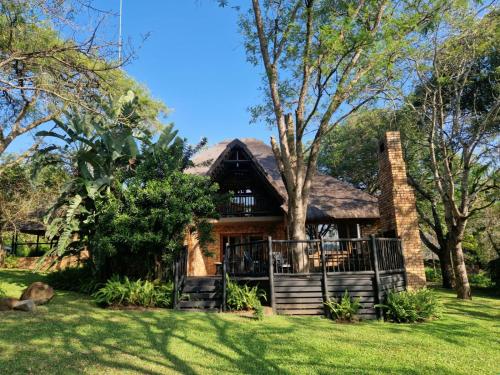 a large house with a tree in the yard at Kruger Park Lodge - Private Villa 514 in Hazyview
