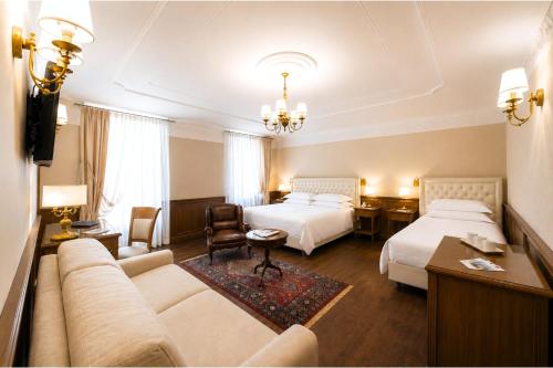 a hotel room with two beds and a couch at Phi Hotel Principe in Cuneo
