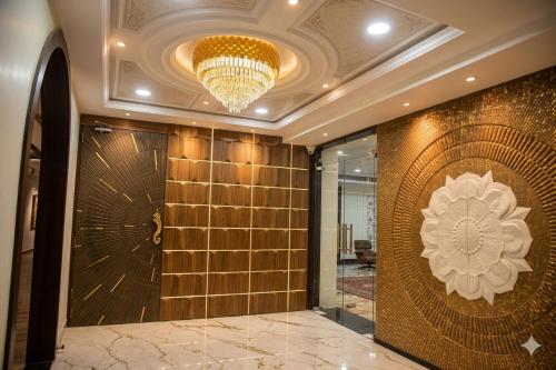 a lobby with a gold tile wall and a chandelier at Hotel Radiant Inn in Morena
