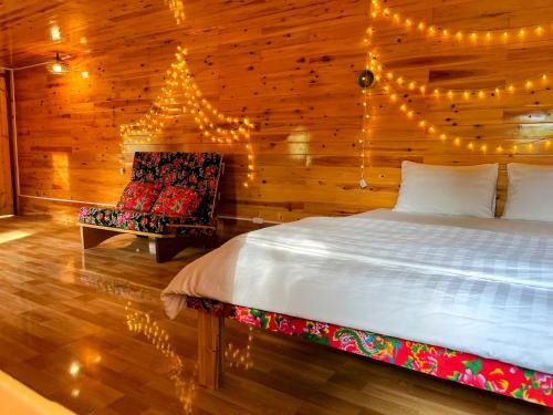 a bedroom with a bed and a chair and lights at The Happy Cozy Corner! in Lao Cai