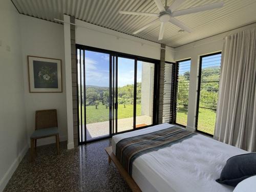 a bedroom with a bed and a large window at Cooktown Getaway in Cooktown