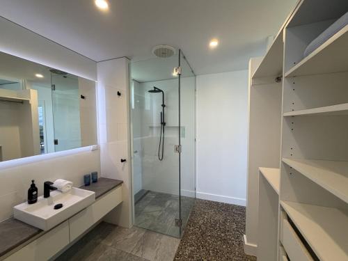 a white bathroom with a sink and a shower at Cooktown Getaway in Cooktown