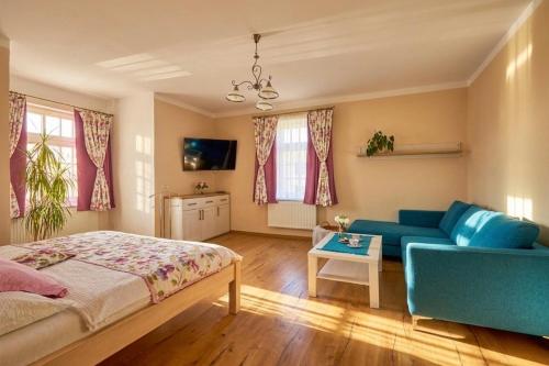 a bedroom with a bed and a blue couch at Villa Harmony in Český Krumlov
