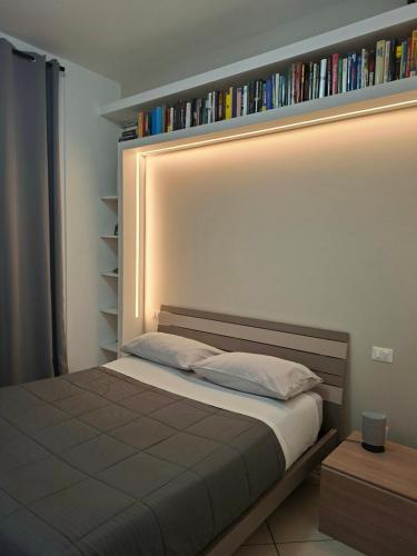 a bedroom with a bed with a book shelf at Atene Bilocale in affitto breve in Milan