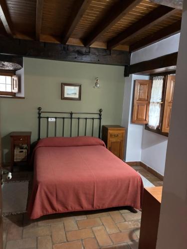 a bedroom with a bed with a red blanket at rincón de covadonga in Caño