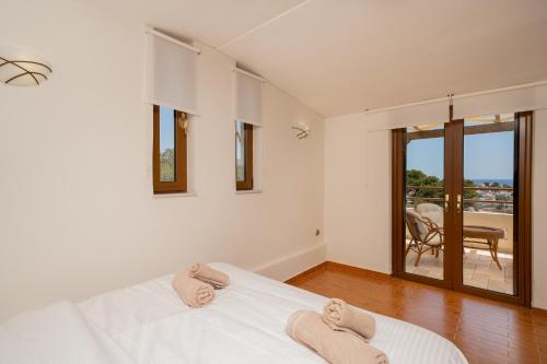 a bedroom with a bed with two towels on it at Theros Maisonette by A&D Properties in Porto Rafti