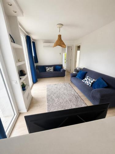 a living room with a blue couch and blue pillows at Apartamento con piscina cerca de Barcelona in El Masnou