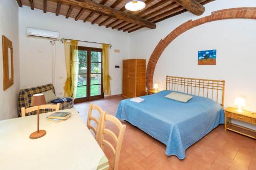 a bedroom with a bed and a table and chairs at Residence La Casaccia in Venturina Terme