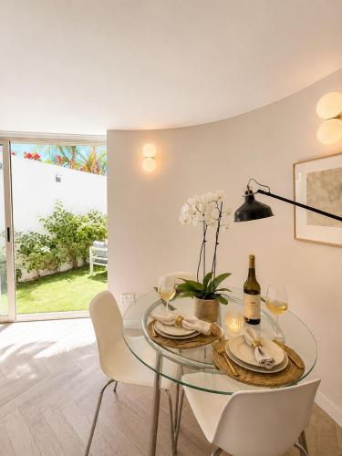 a dining room with a glass table and white chairs at Noa's Place in Eilat