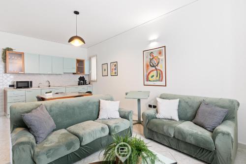 a living room with two couches and a kitchen at Estay - Casa Bo' in city center - AirCon - WiFi in Tortolì