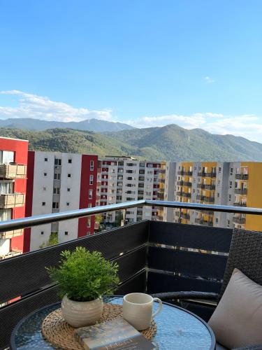 a table on a balcony with a view of buildings at Brasov Altipiani Apartments in Braşov