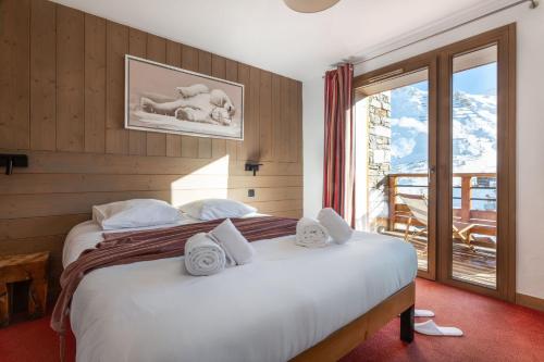 a bedroom with a large bed and a balcony at Résidence Almes 1 et Almes 2 by Alpapart in Tignes