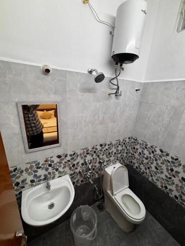 a bathroom with a toilet and a sink at Sai Meridian in Pondicherry