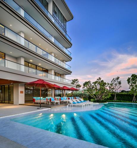 a swimming pool in front of a building at The Panora Estuaria Pattaya in Na Jomtien