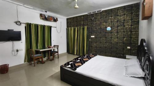 a bedroom with a bed and a desk and a television at LlBRA REGENCY in Guruvāyūr