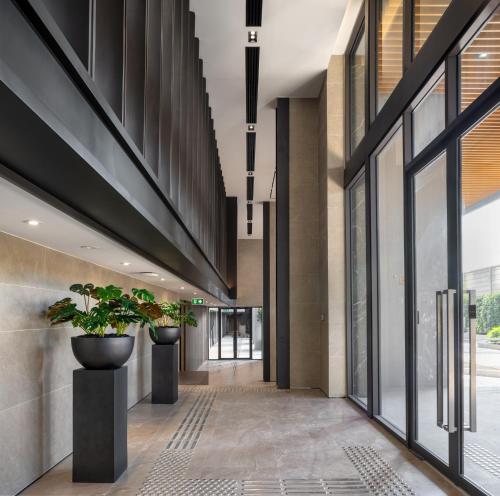 a hallway with potted plants in a building at The Panora Estuaria Pattaya in Na Jomtien