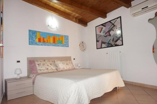 1 dormitorio con 1 cama con colcha blanca en Bergamum F.L., en Bérgamo