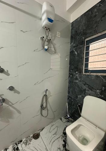 a bathroom with a white toilet and a shower at SS Hostel Siliguri in Siliguri