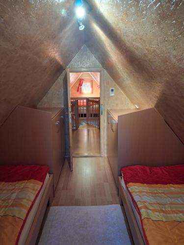 a attic room with two beds and a hallway at Haus Marlies in Spielberg