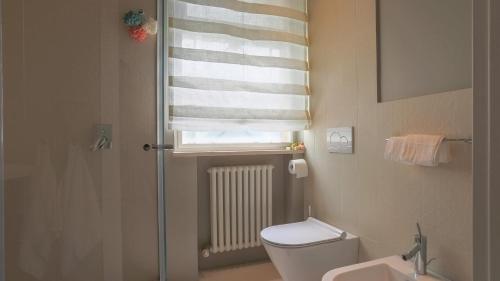 a bathroom with a shower and a toilet and a window at VILLA CORONA 8, Emma Villas in Cattolica
