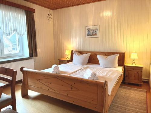 a bedroom with a large wooden bed with white sheets at Seetuun-Hoff - Studio in Nordstrand