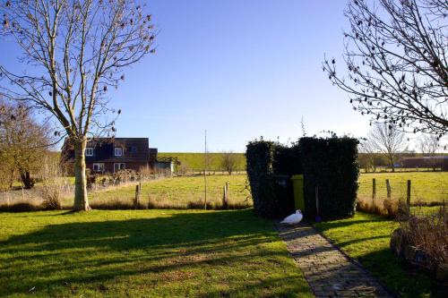 a garden with a fence and a field with a house at Süderhafen 2c in Nordstrand