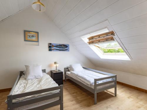 a attic bedroom with two beds and a skylight at War Ar Maez in Pleumeur-Bodou