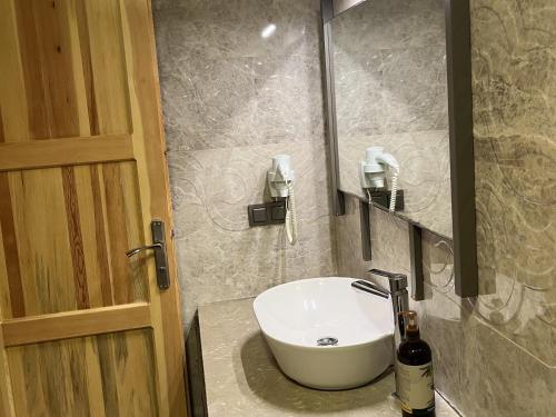 a bathroom with a white sink and a door at Melinda Pension & Restaurant in Mesudiye