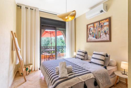 a bedroom with a bed and a large window at Atlas Views Appartements avec Piscine Golf de Marrakech in Marrakesh