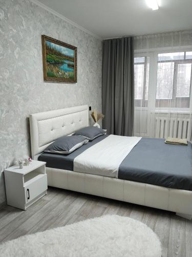 a bedroom with a king sized bed and a rug at Строитель 39 in Oral
