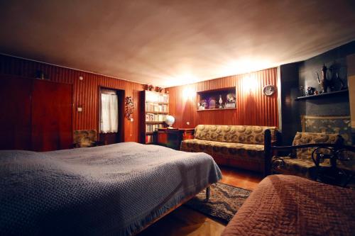 a bedroom with a bed and a couch at Apartment Gardenia in Kutaisi