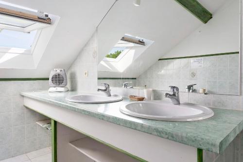 a bathroom with two sinks and a window at Chambres D'hotes Vignolo in Pontiacq-Viellepinte
