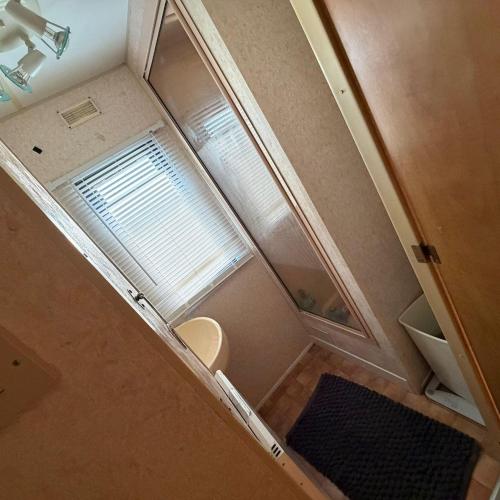 an overhead view of a small bathroom with a window at Static Caravan Sleeps 8 with Indoor Pool in Clacton-on-Sea