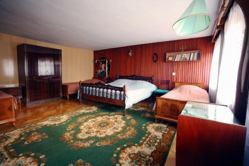 a bedroom with a bed and a green rug at Apartment Gardenia in Kutaisi