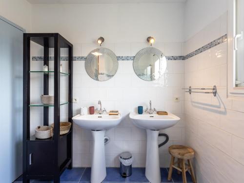 a bathroom with two sinks and two mirrors at War Ar Maez in Pleumeur-Bodou