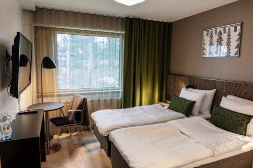 a bedroom with a large bed and a large window at Hotel Rantapuisto in Helsinki