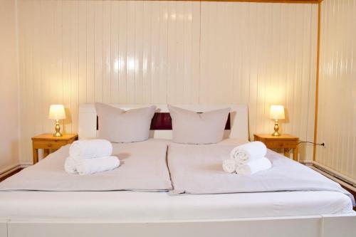 a white bed with two towels on top of it at Seetuun-Hoff - Dree in Nordstrand