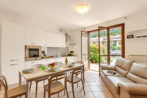 a kitchen and living room with a table and a couch at Juliette House: Shared Pool & Relax - Happy Rentals in Salò