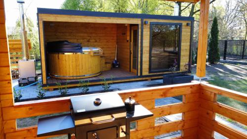 a house on a deck with a hot tub at Zacisze domek z Jacuzzi & Sauna in Chrołowice