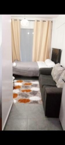 a living room with a bed and a couch at Tembea Stays in Kiambaa