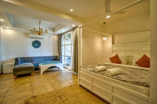 a bedroom with a bed and a blue couch at Casa Pajaros in Calangute