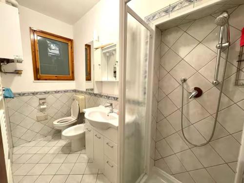 a bathroom with a shower and a toilet and a sink at Casa Ariel in Lido Adriano