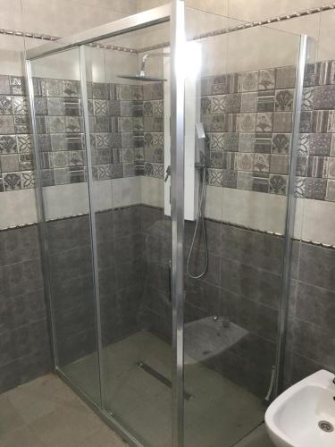 a shower with a glass door in a bathroom at Casa hersi in Hennchir Ksar Rhaleb