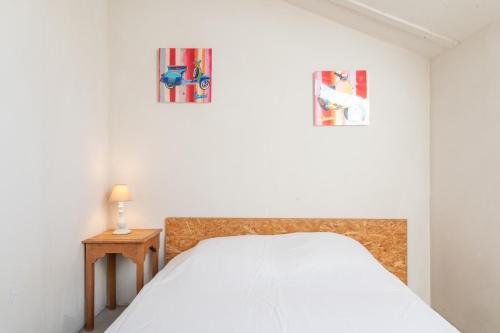 a bedroom with a bed and two pictures on the wall at La Terrasse in Patrimonio