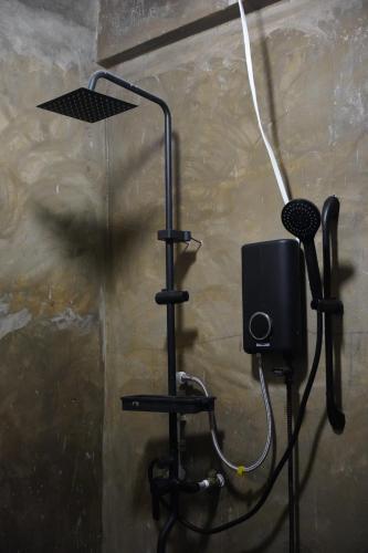 a shower with a fan and a speaker on a wall at yolked suites in General Luna