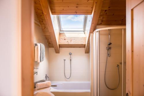 a bathroom with a tub and a shower and a sink at Residence Walder in Falzes