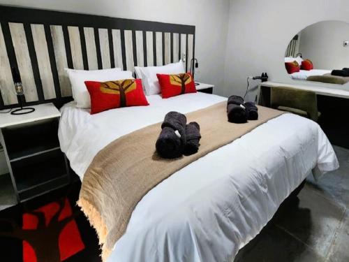 a bedroom with a large white bed with red pillows at Nonaka in Louis Trichardt